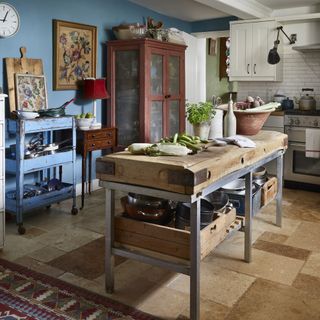 Freestanding kitchen with an old butcher block serving as a kitchen island and various upcycled vintage cabinets