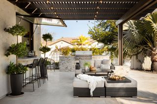 a modern patio with a serving hatch and an outdoor kitchen