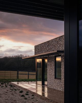Stone clad exterior of new Kent house by BakerBrown at sunset