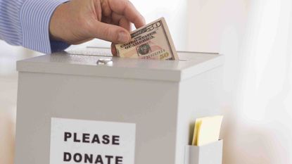 Photo of a hand putting money in a donation box
