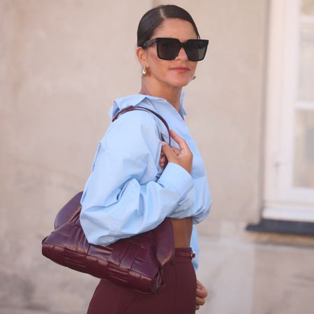 woman wearing blue button-down shirt and burgundy pants 