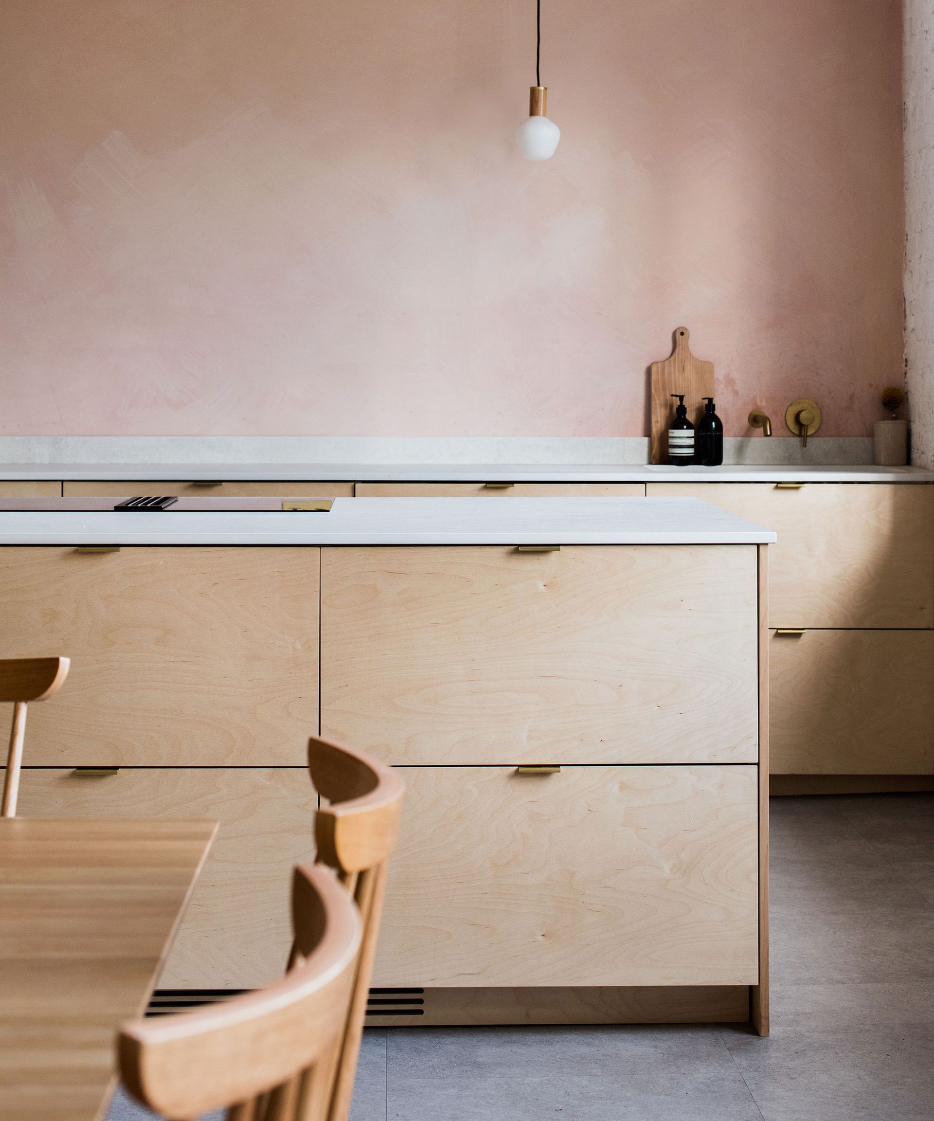 used kitchen with plywood cabinets and plaster wall