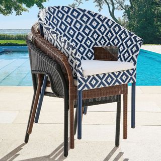 Palmetto Stackable Outdoor Armchair in front of a pool.