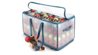 A filled clear plastic ornament storage box with blue handles and a blue zipped top, for the best ornament storage containers.