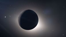 An image of the dark sphere of the moon in space as it blocks the sun, with a glowing sphere of light behind it. 