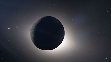 An image of the dark sphere of the moon in space as it blocks the sun, with a glowing sphere of light behind it. 