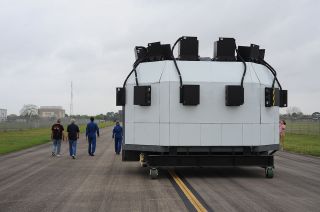 NASA's Shuttle Mission Simulator-Motion Base is seen from behind as it is towed down the taxiway at Ellington Airport to the Lone Star Flight Museum in Houston on Tuesday, April 12, 2022.
