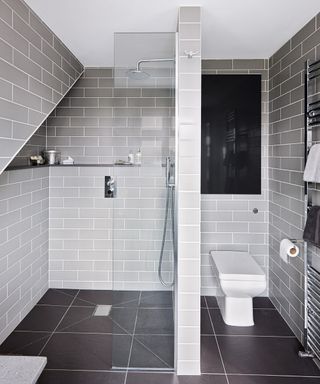 bathroom with grey tiles and white fixtures