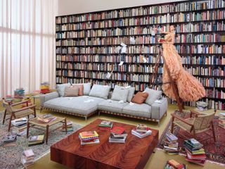 Woman in elaborate dress on ladder beside bookcase and Flexform sofa
