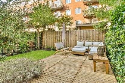 A small backyard with decking and garden furniture