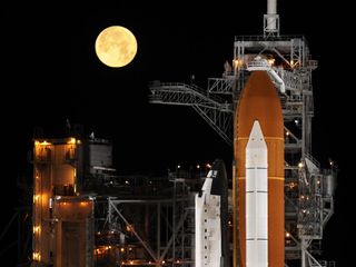 Under a full moon on Launch Pad 39A at NASA's Kennedy Space Center in Florida, space shuttle Discovery is revealed after the rotating service structure has been rolled back in preparation to launch on mission STS-119 to the International Space Station. Th