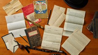 A collection of letters, notebooks and other documents lying on a table