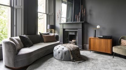 Grey living room with grey sofa and burning woodburner