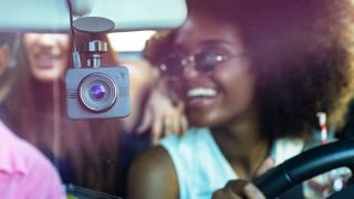 Nexar Beam dash cam on windscreen of car being driven by a black woman wearing sunglasses