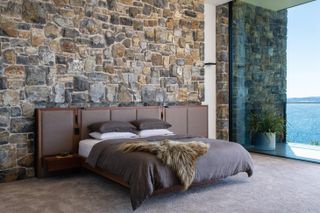 A bespoke grey bed in the guest bedroom in Tinderbox House by Studio Ilk Architecture
