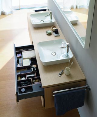 A bathroom vanity with drawer dividers and personal care products