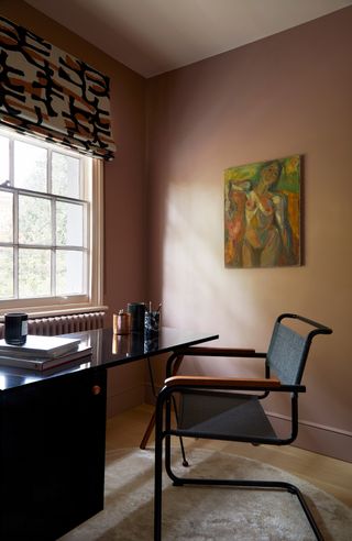 A home office with walls painted in deep earthy pink