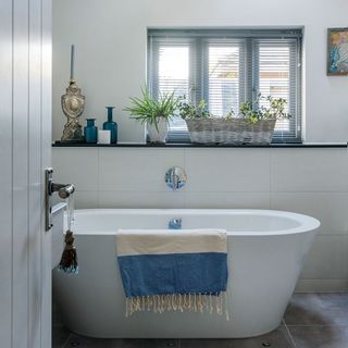 bathroom with white bathtub and potted plants