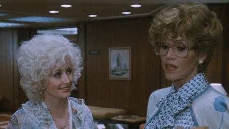 Dolly Parton smiling at Jane Fonda in 9 to 5. 