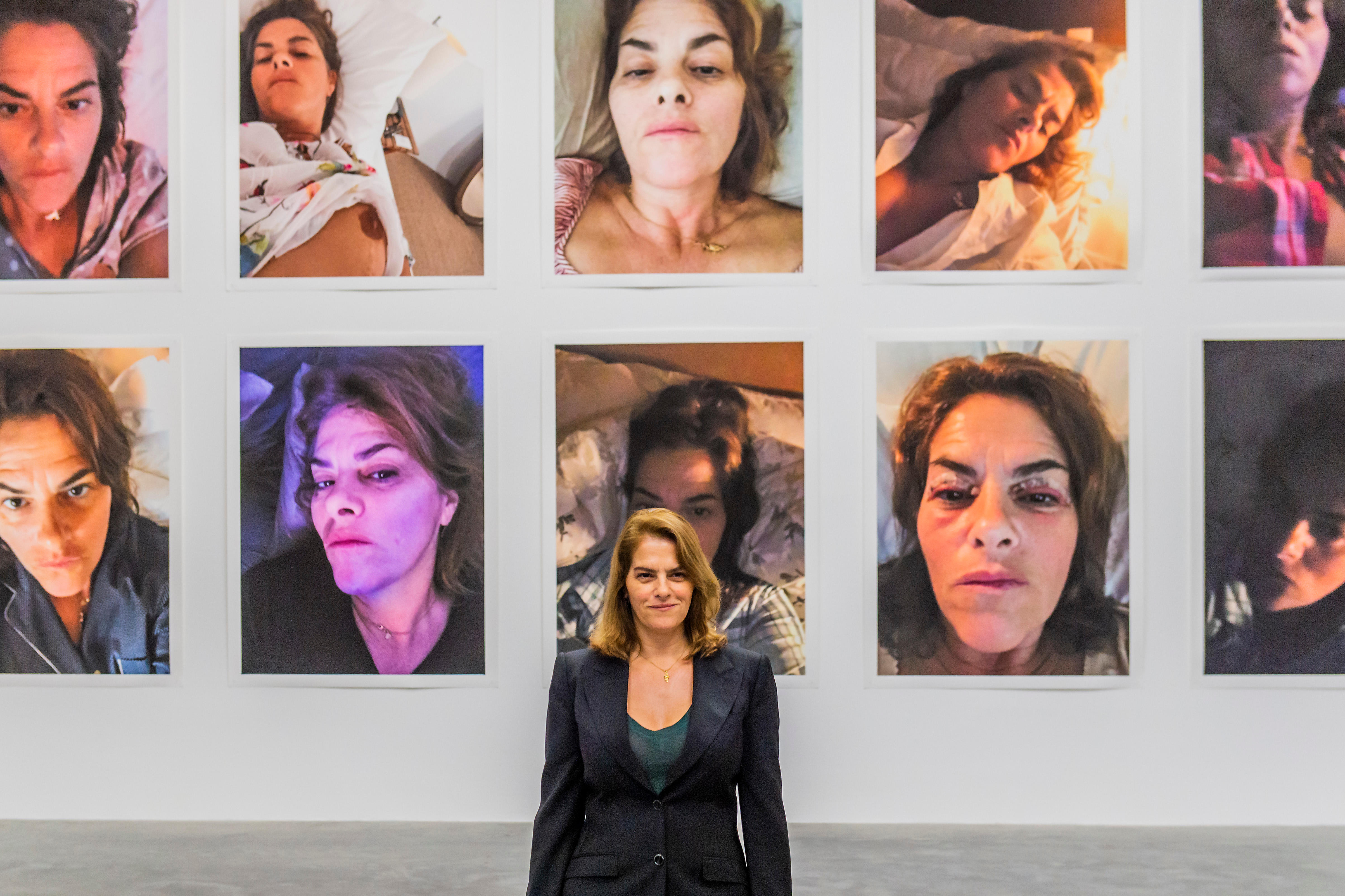 Tracey Emins stands infront of several self-portraits