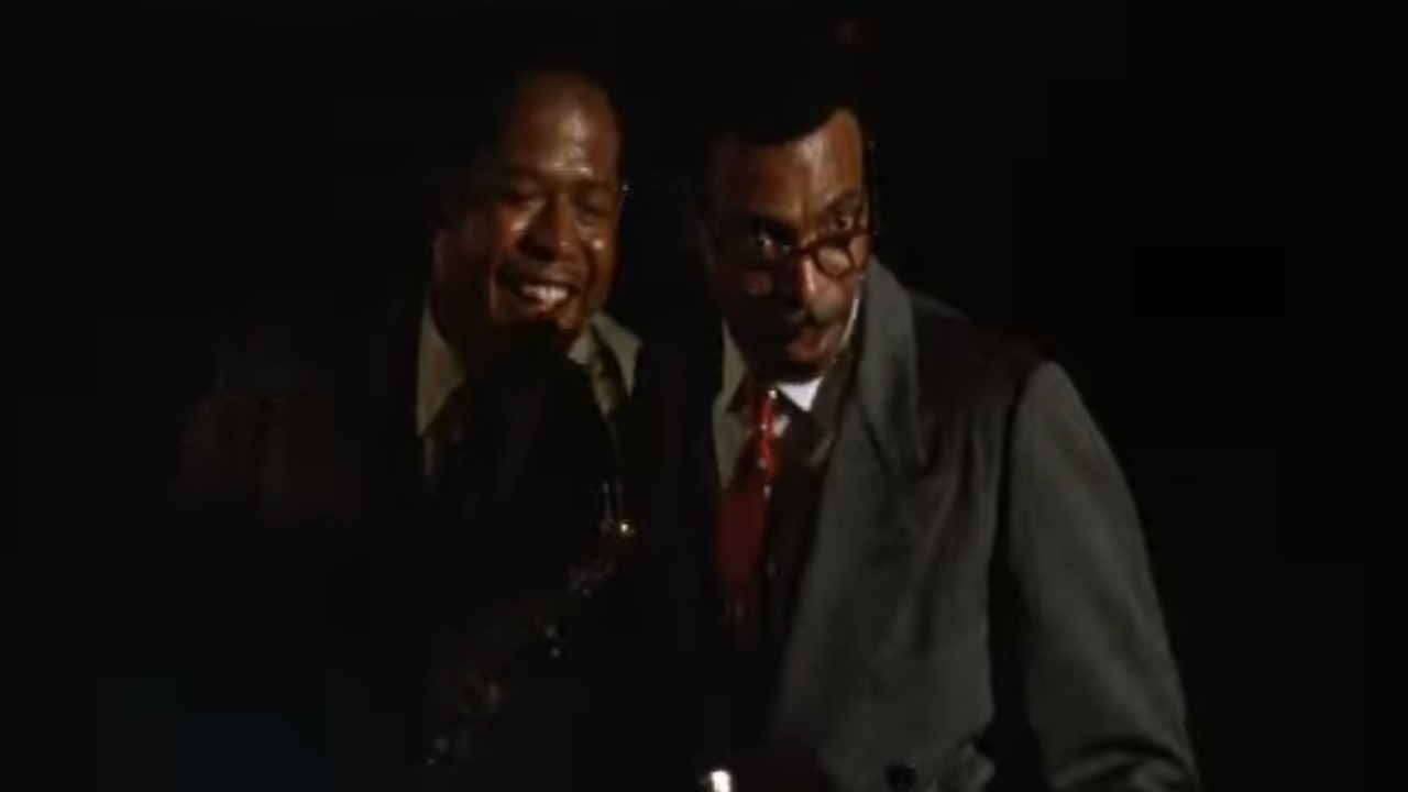 Forest Whitaker laughing as Samuel E. Wright looks over his glasses in Bird