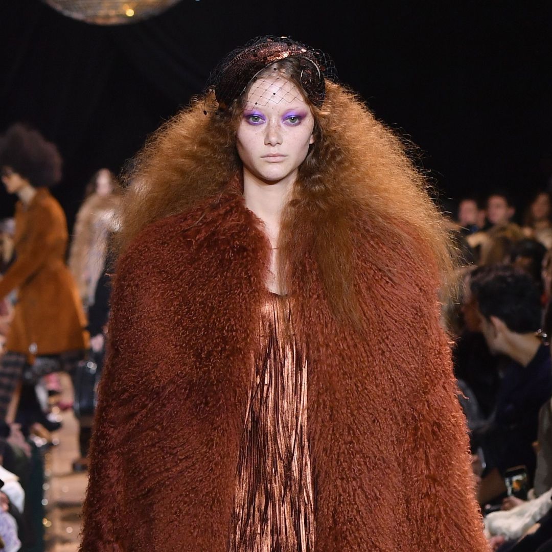 a model on the runway wearing a fur coat