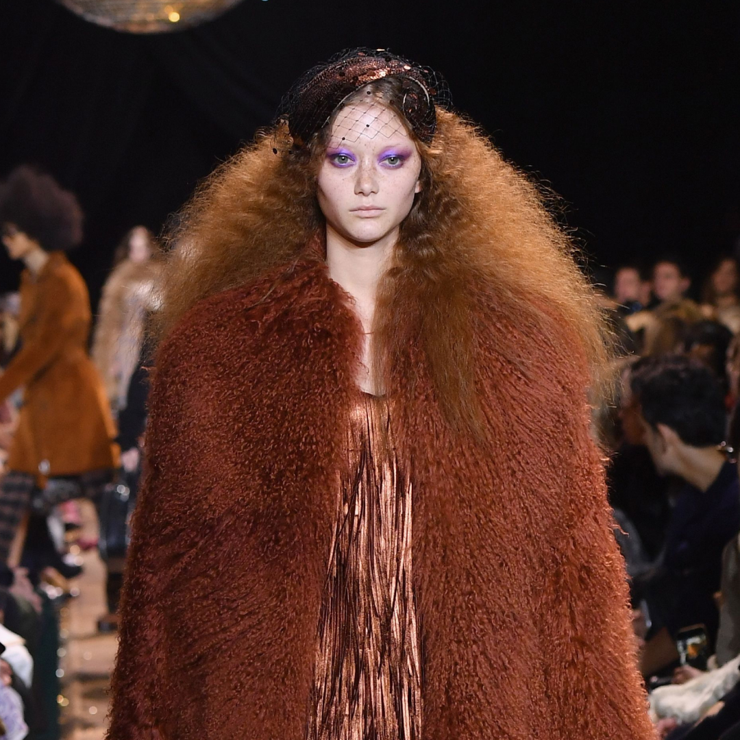 a model on the runway wearing a fur coat