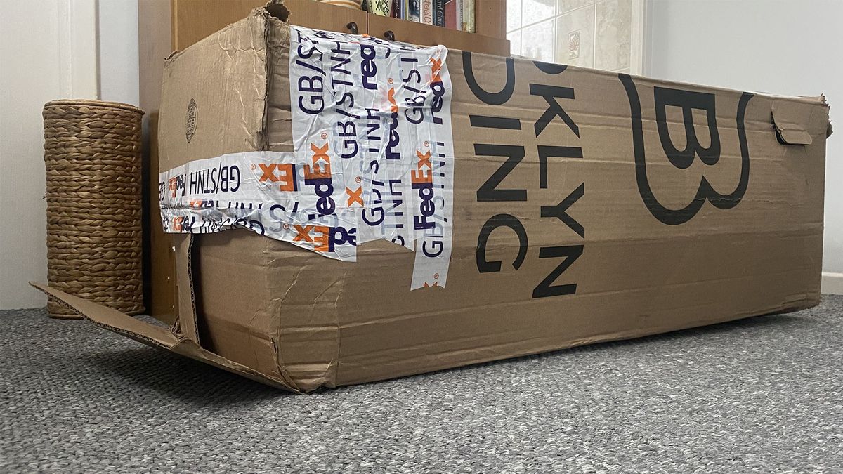 The Plank Firm Mattress in a slightly battered box in the reviewer's home
