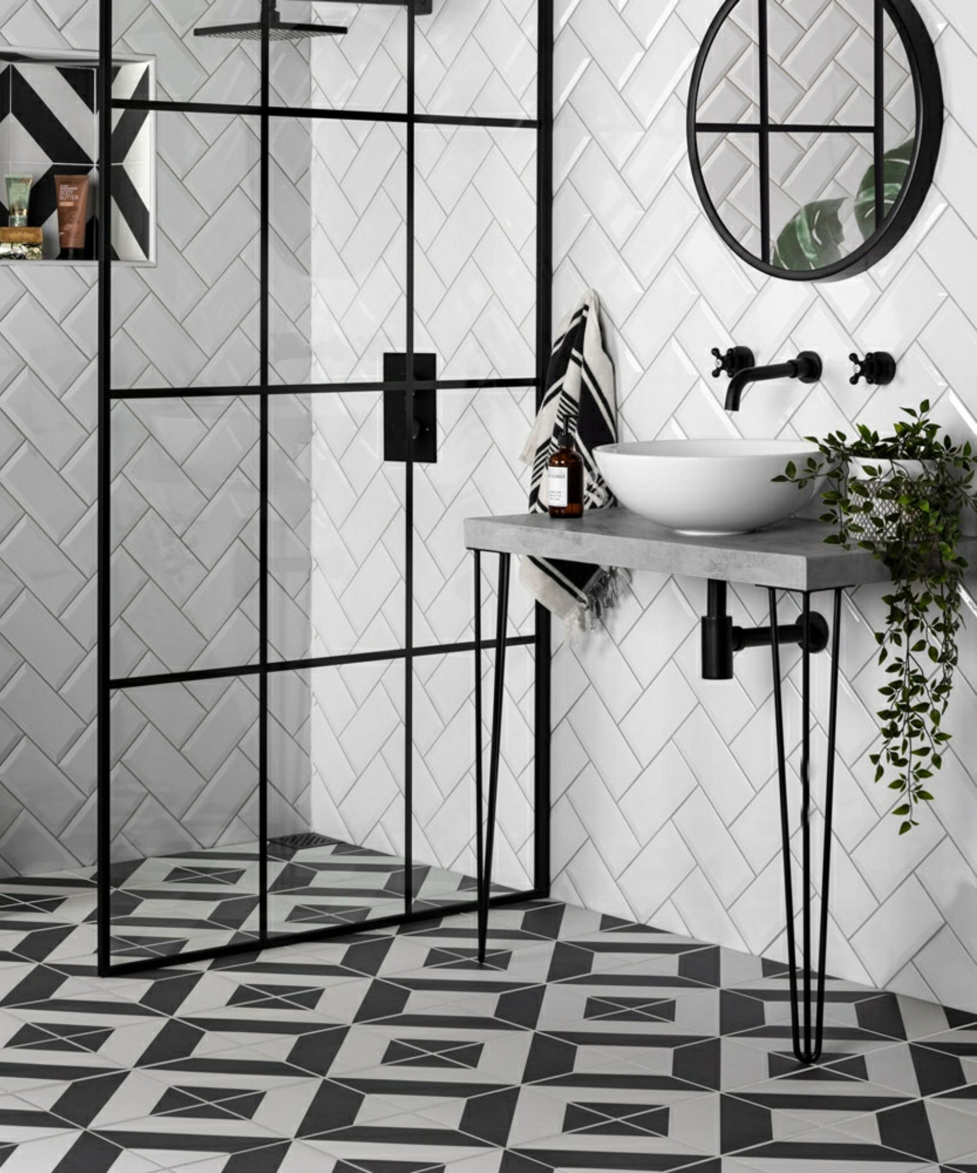 black and white chevron wall tiles in shower room with hairpin legged vanity unit and black framed shower screen