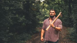 A lumberjack carrying an axe on their shoulder