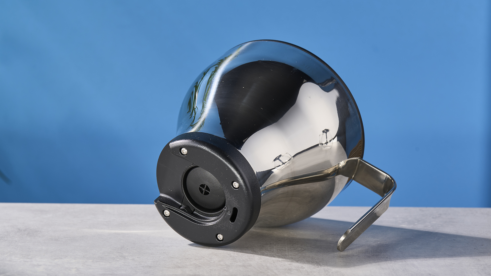 a silver drip coffee maker with a capacity of 10 cups is photographed against a blue background