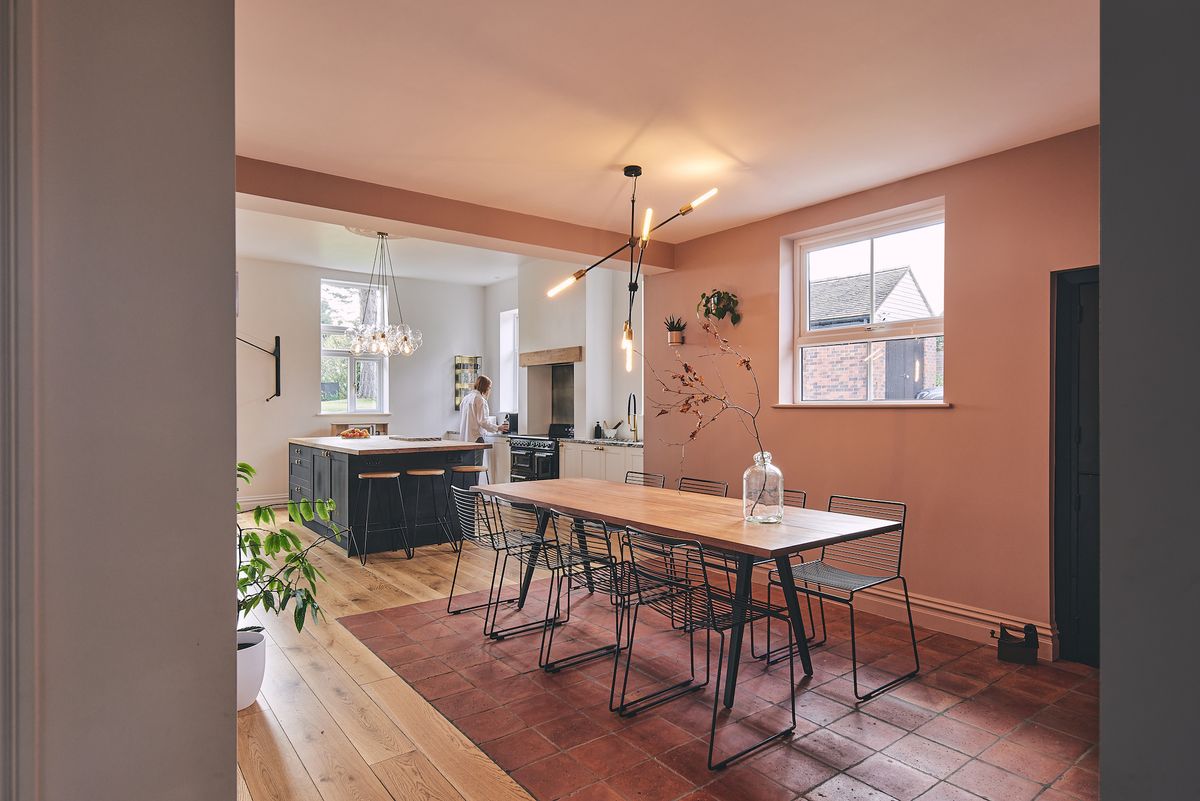 pink dining room with view to white kitchen with island