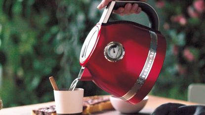 KitchenAid Variable Temperature Kettle in red pouring water into a mug
