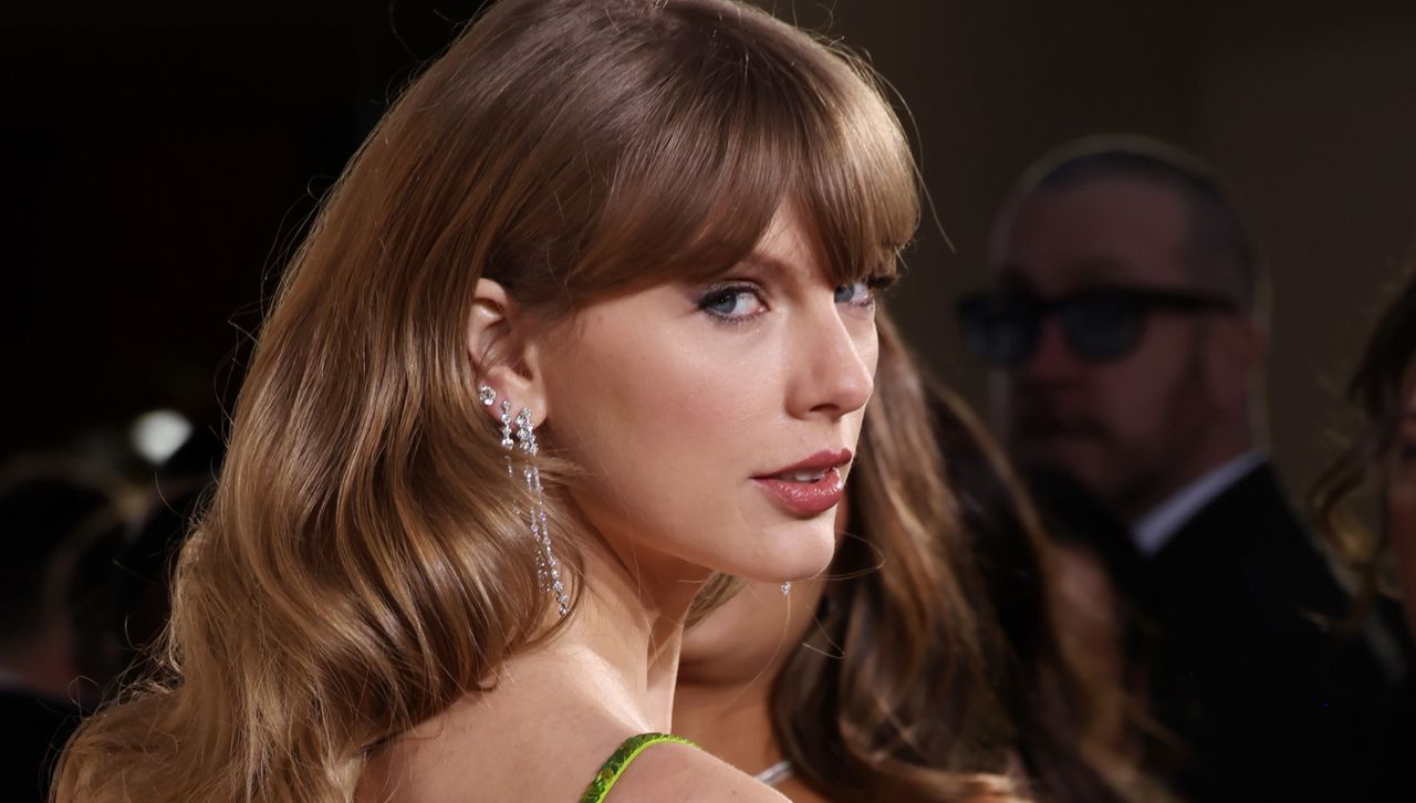 Taylor Swift on the Golden Globes carpet wearing several diamond earrings and a green Gucci dress