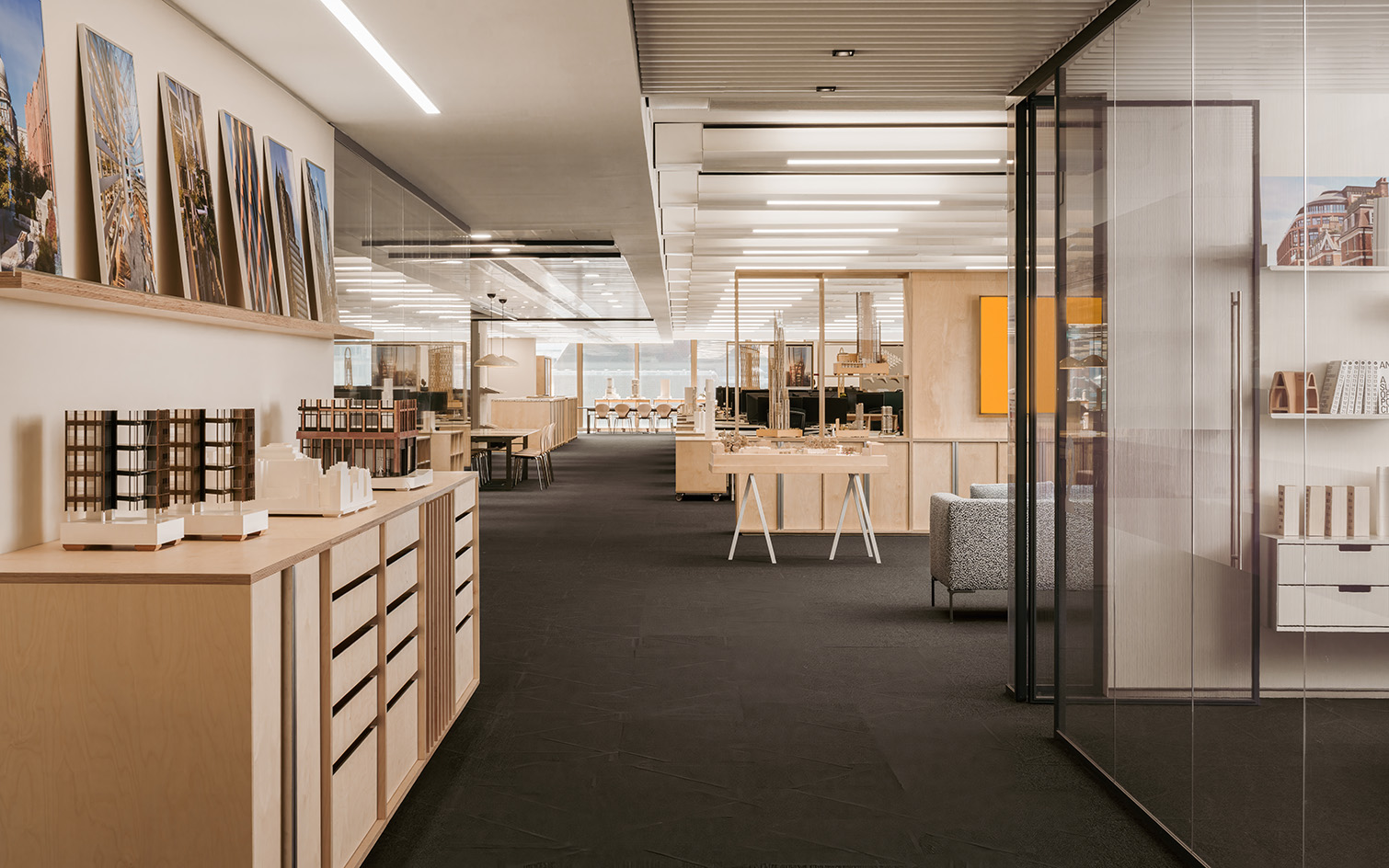 PLP Architecture&#039;s circular office design in neutral colours and soft light, showing empty workspace and timber seating and desks