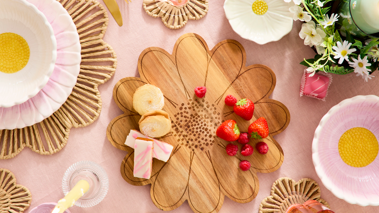 Daisy-themed tableware on a pink tablecloth