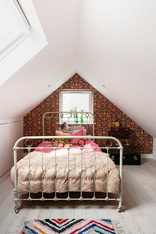 Kid's bedroom with a vintage metal bed and floral wallpaper