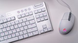 Gaming-tastaturet Logitech G915 TKL Lightspeed og en mus på en bordplate.