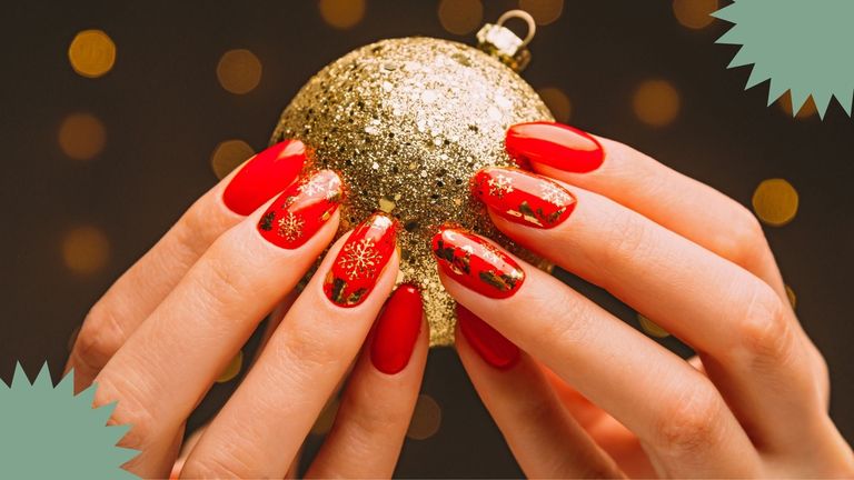 A woman with snowflake nail art holding a christmas bauble with twinkly background lights