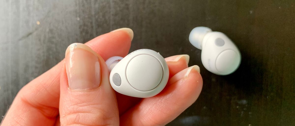 Sony WF-C700N earbuds held in a hand