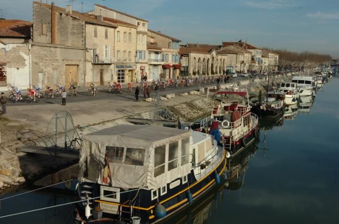 The peloton pass along a canal on Stage 1 from Bellegarde to Beaucaire