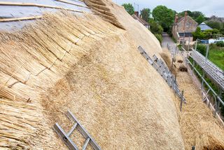 An old barn being re thatched in the Dorset village of Symondsbury, Dorset UK