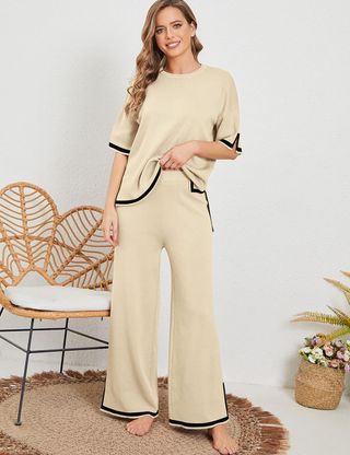 model wears cream knit set that has a wide leg and black lining 