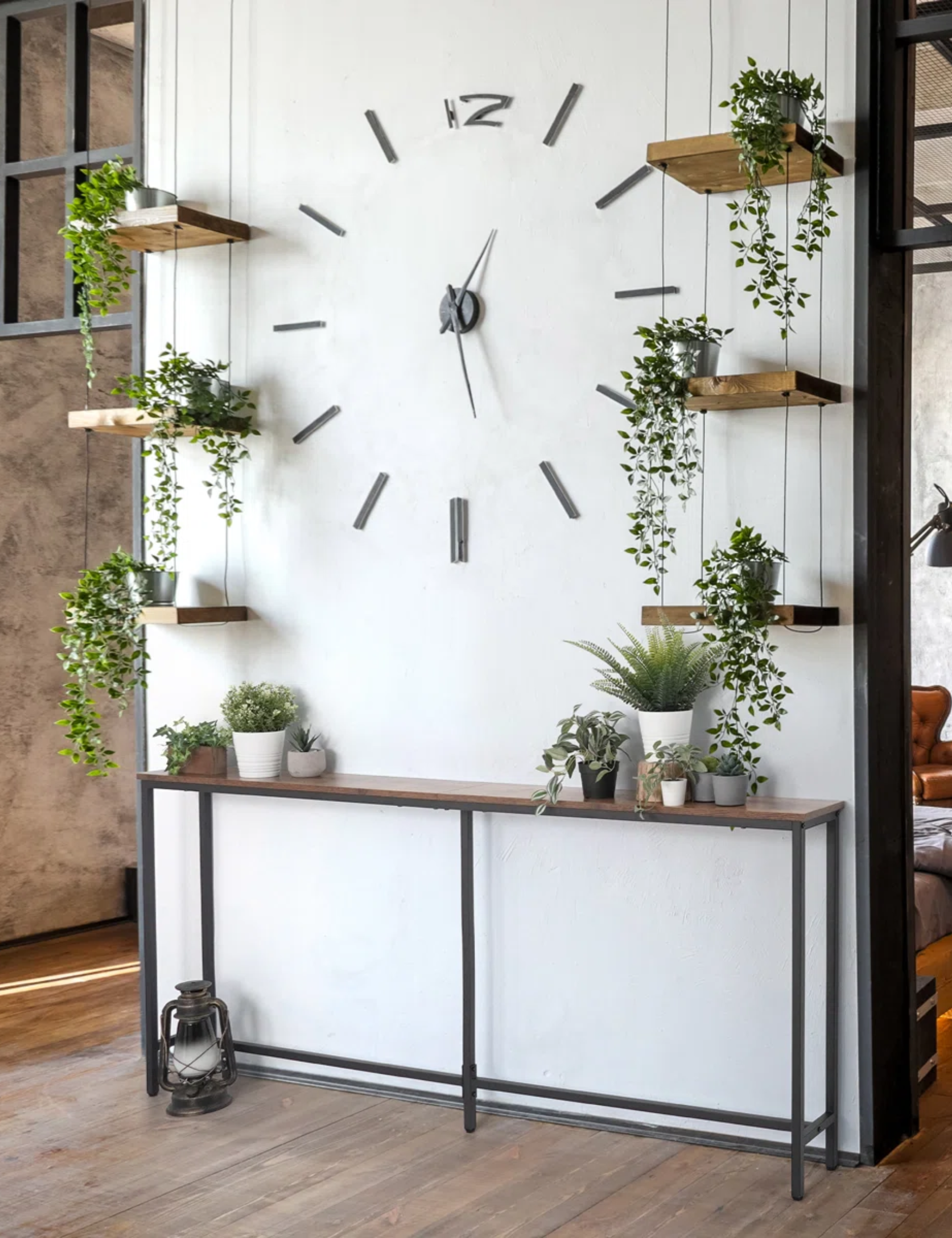 Skinny console table pictured in a natural entryway area that is styled with lots of lush potted plants