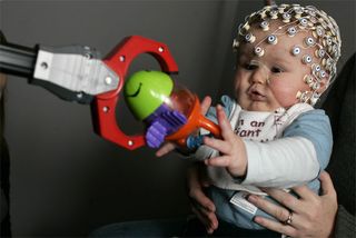 Electrodes recorded brain activity while infants grabbed for toys. The same brain area showed activity whether infants grabbed for a toy themselves or watched an adult do the same.