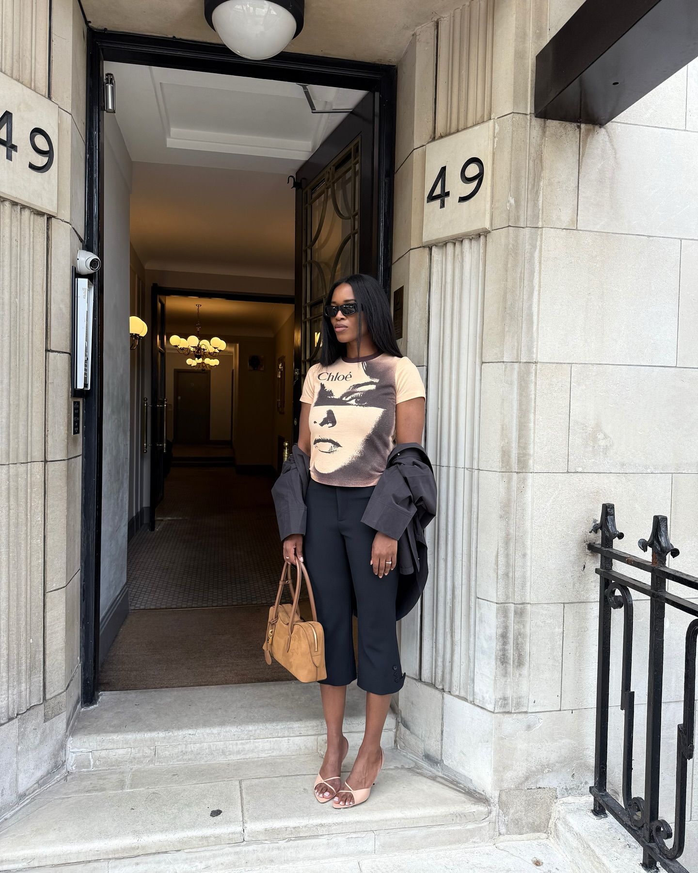 An image of @nlmarilyn wearing black capri pants with a statement graphic t-shirts, one of the key autumn London fashion trends 2025.