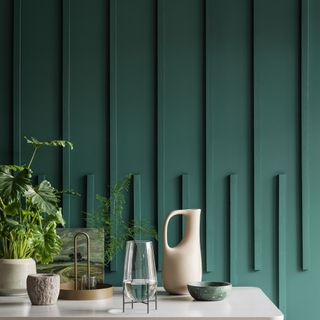 Contemporary wall panelling design painted bottle green with console unit next to it