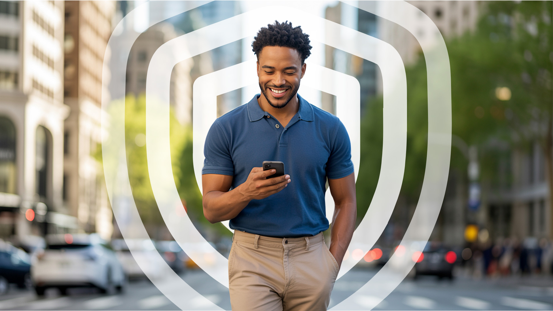 A man in a blue shirt looks happily at his phone