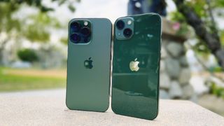 Alpine Green iPhone 13 Pro and Green iPhone 13 Pro upright on a bench