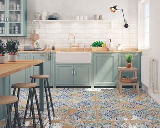 A modern traditional kitchen idea with pastel green kitchen furniture and distressed look floor tiles